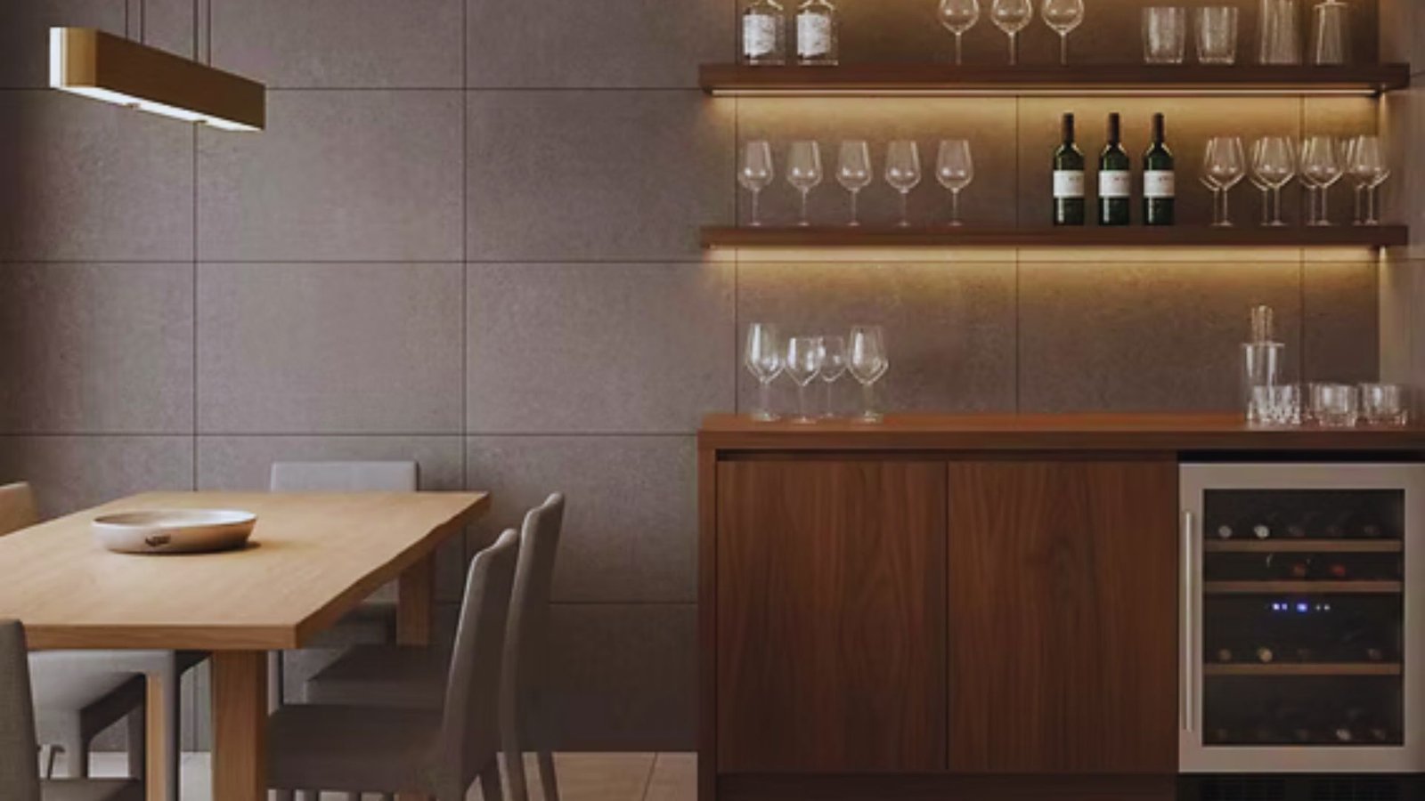 Modern dining area with a wooden table and four chairs on the left, and a bar setup on the right with shelves holding glasses and wine bottles. Warm lighting creates an inviting atmosphere.