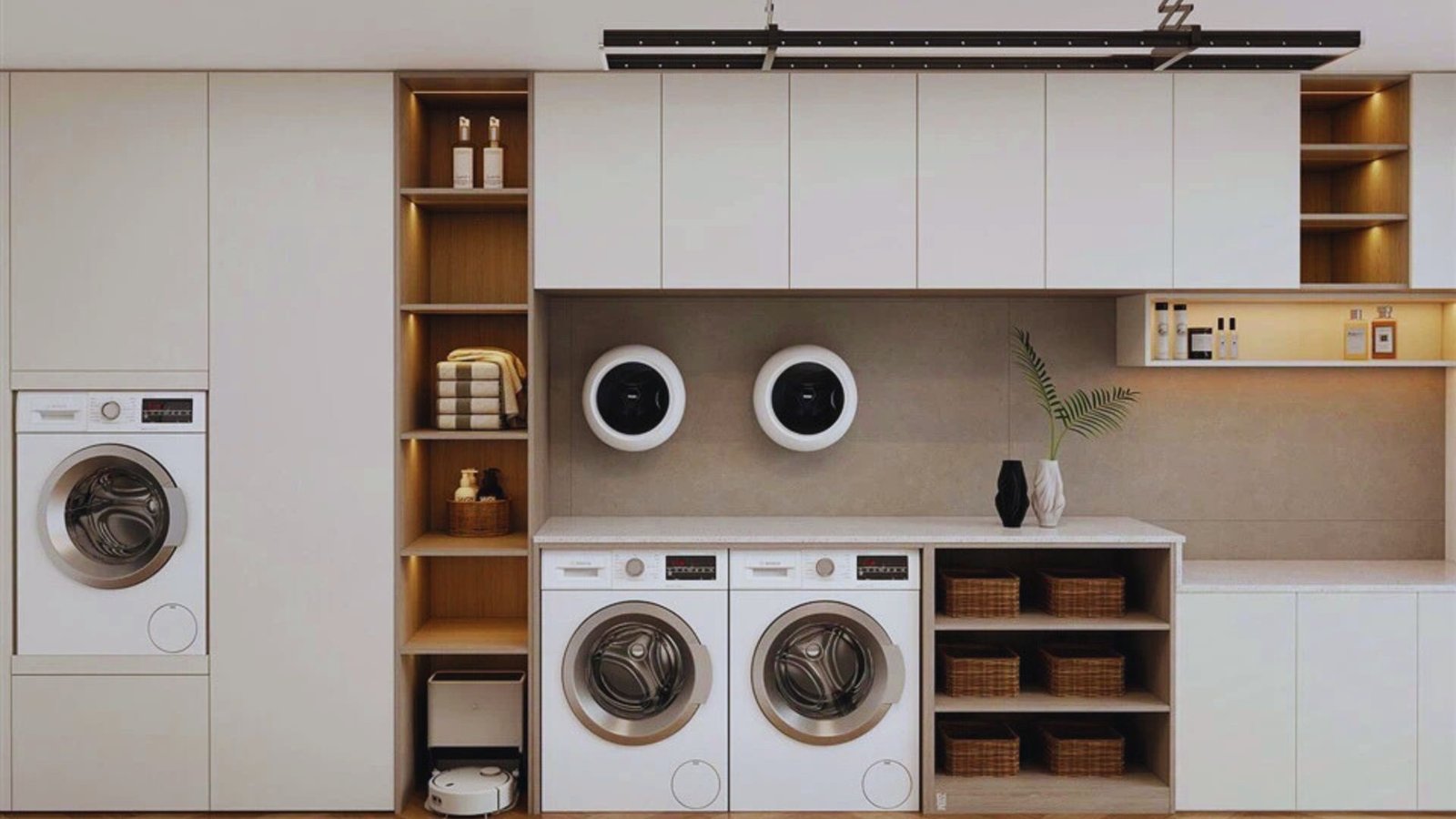 Modern laundry room with sleek white cabinetry and built-in washers. Open shelves display baskets and plants, creating a tidy, stylish space.