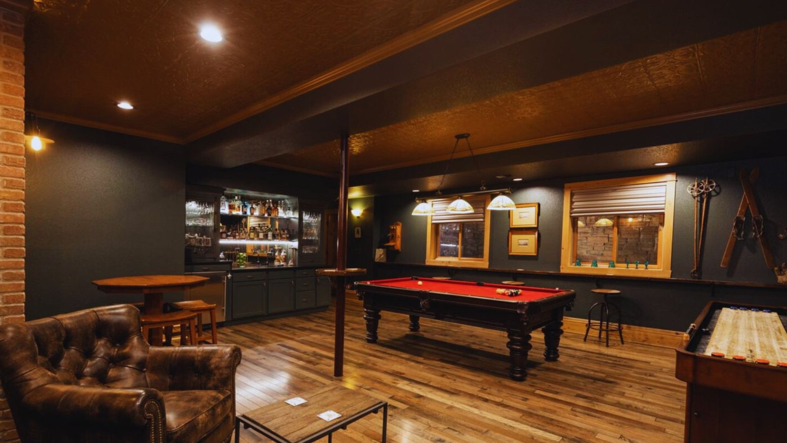 A game room featuring a pool table and a stylish bar area, designed for entertainment and relaxation.