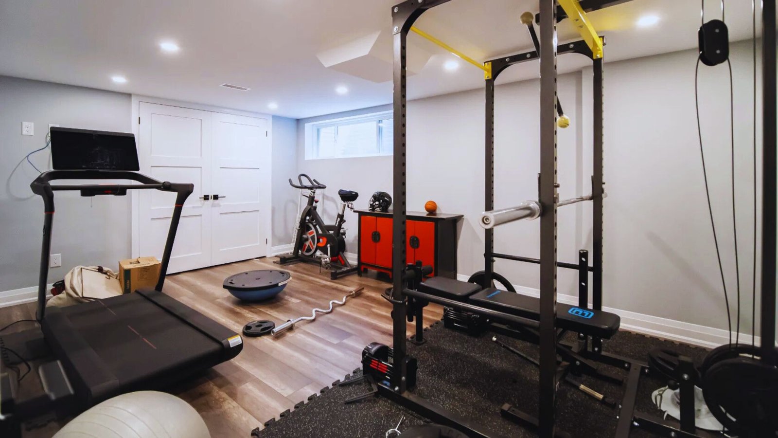  A home gym featuring various exercise equipment and a treadmill, designed for fitness and workout routines.