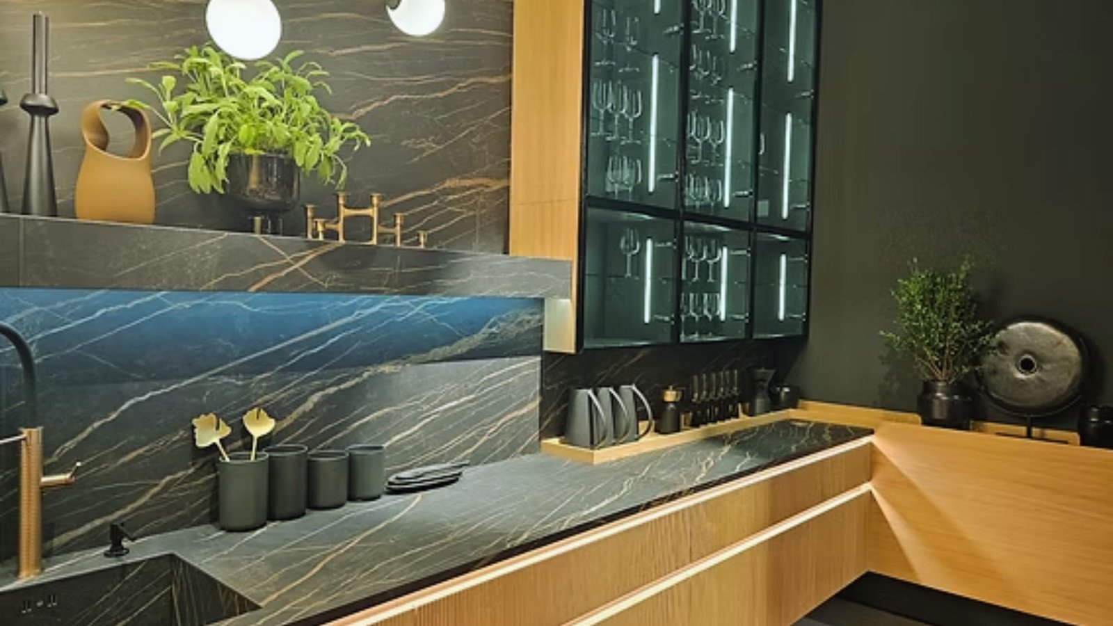 A modern kitchen featuring sleek black marble countertops and a stainless steel sink.