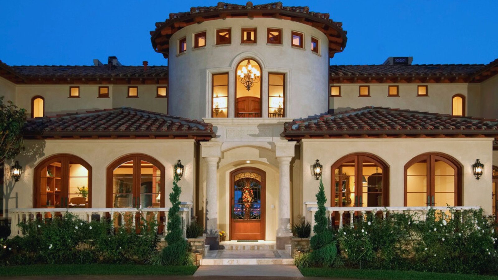 A large home featuring a spacious front porch, showcasing a welcoming and inviting architectural design.