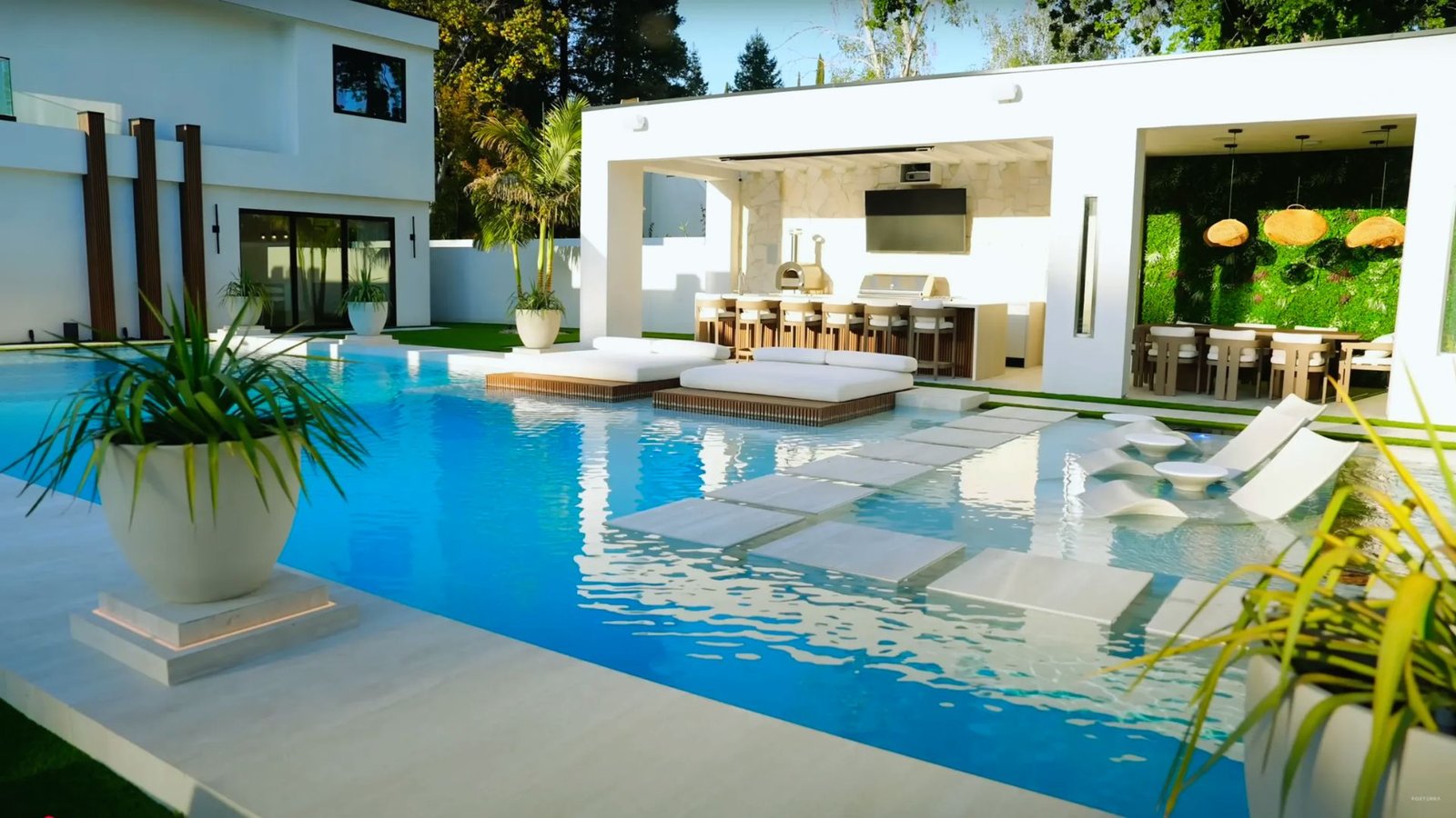 A modern pool surrounded by lounge chairs and a stylish bar, inviting relaxation and leisure.