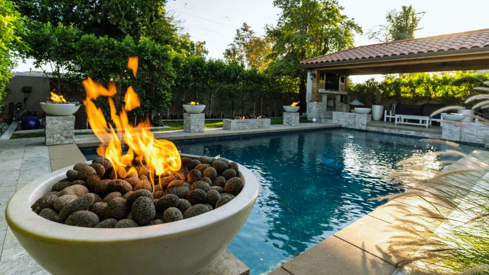 A cozy fire pit surrounded by grass in a residential backyard, perfect for outdoor gatherings and relaxation.