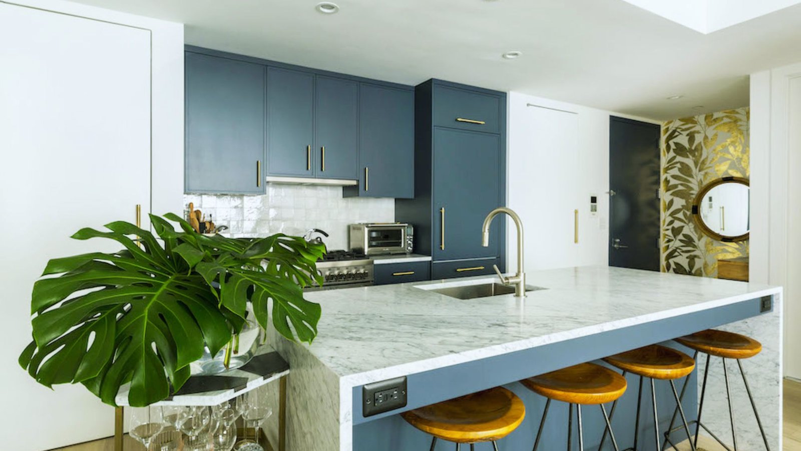 A stylish kitchen with vibrant blue cabinets and a polished marble countertop.
