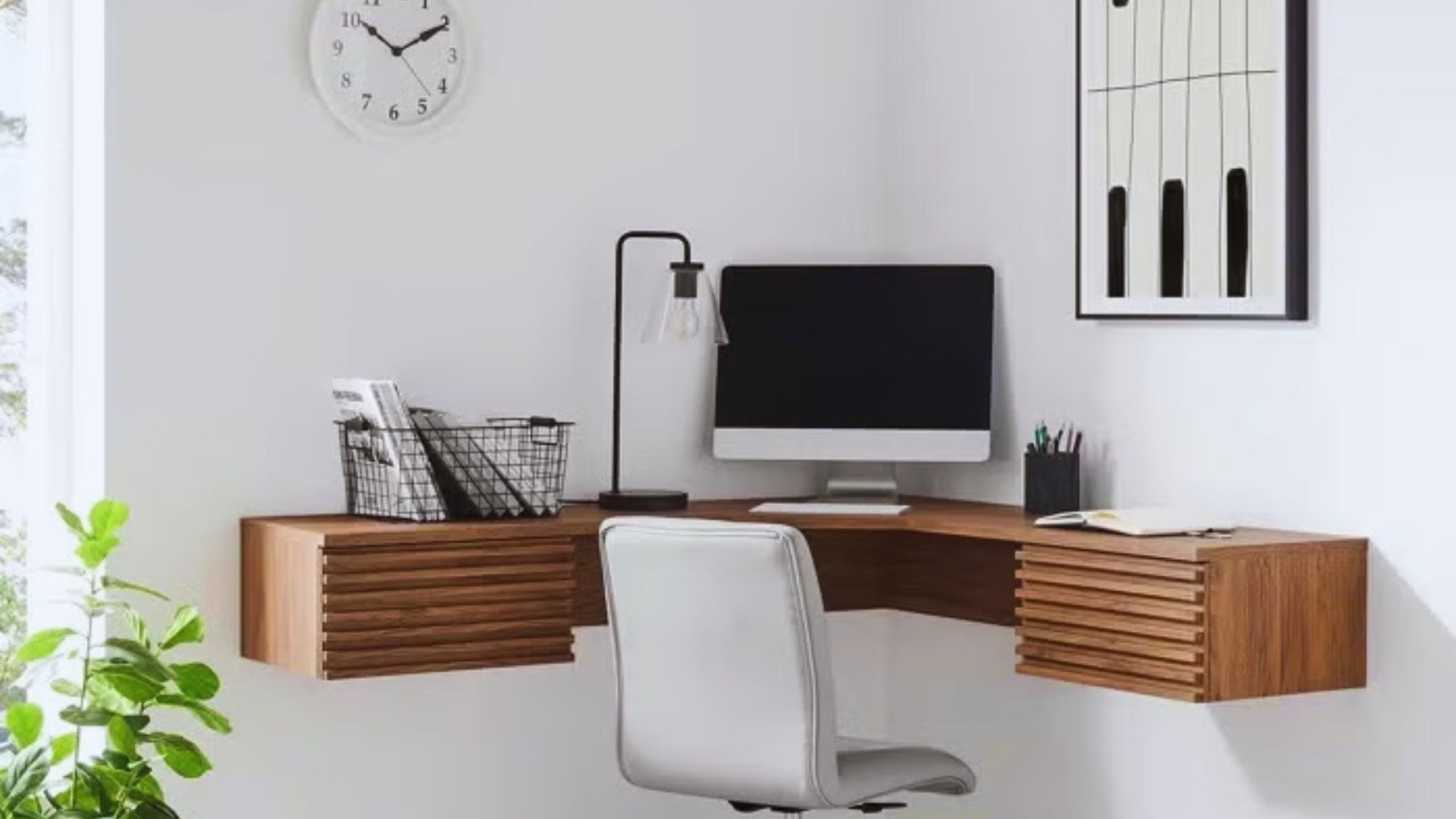 A corner desk featuring a computer and an ergonomic chair, designed for a compact workspace.