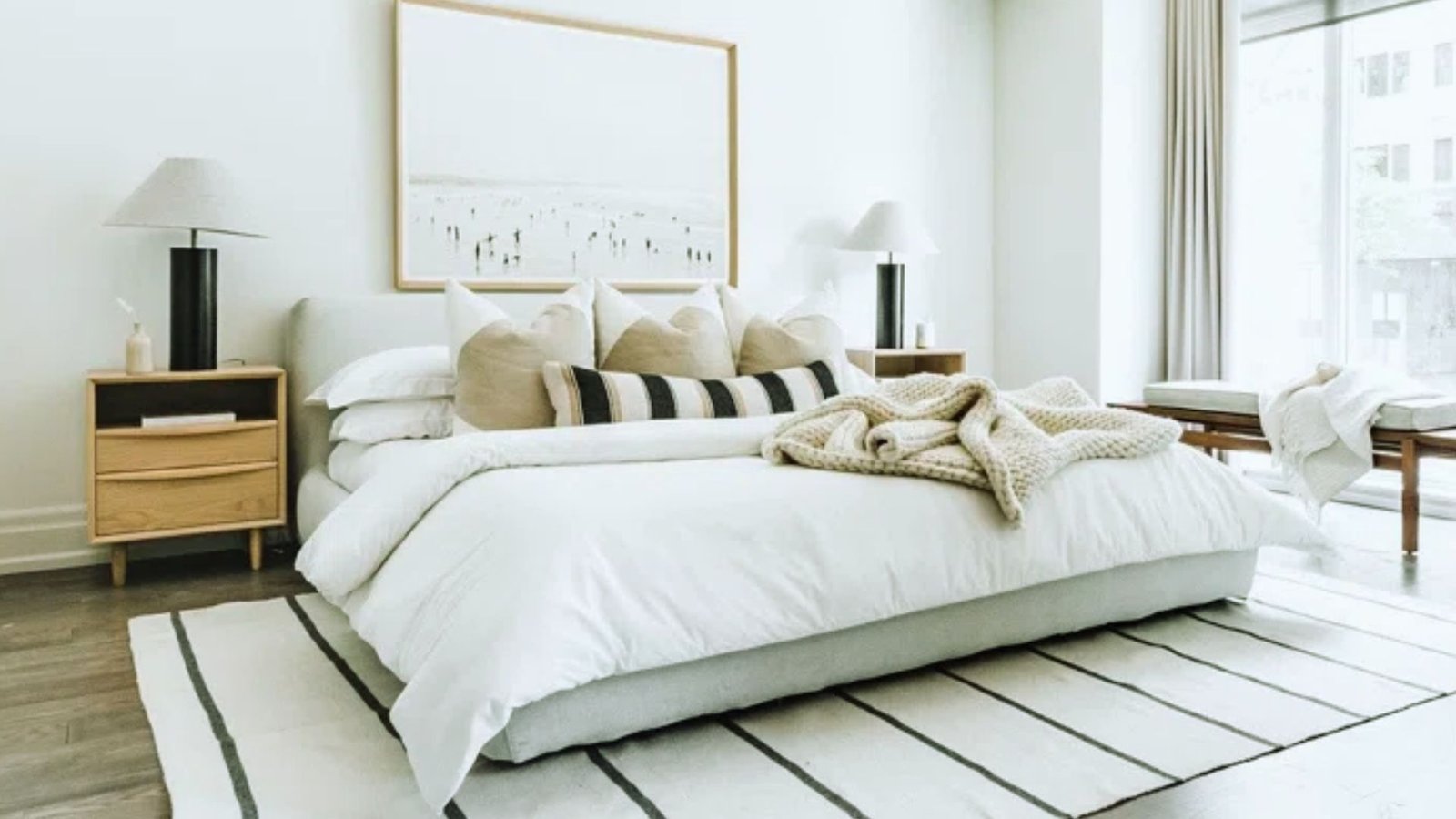 A tidy bedroom featuring white walls and polished wooden floors, creating a bright and inviting atmosphere.