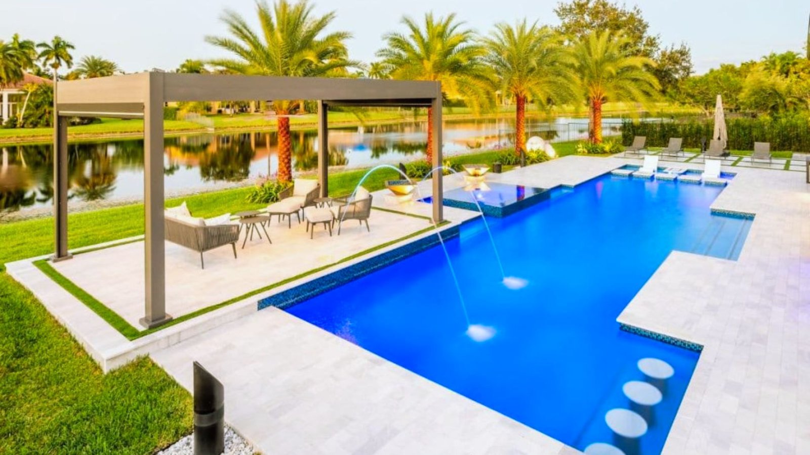 A serene poolside scene featuring a lounge chair and a small table beside the water.