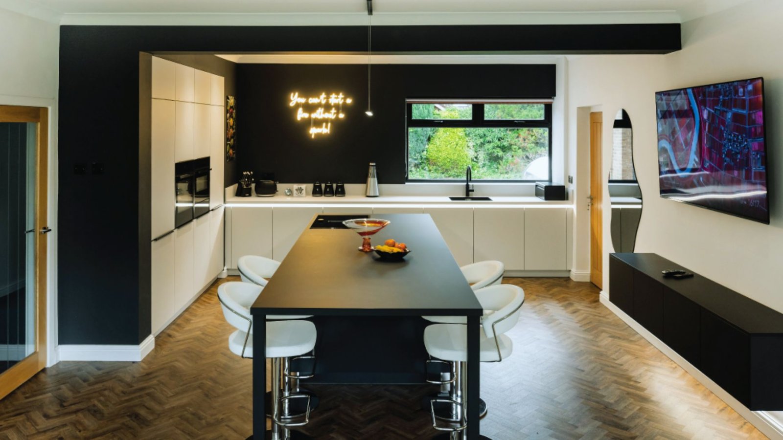 A sleek modern kitchen featuring stylish black and white accents throughout the cabinetry and decor.
