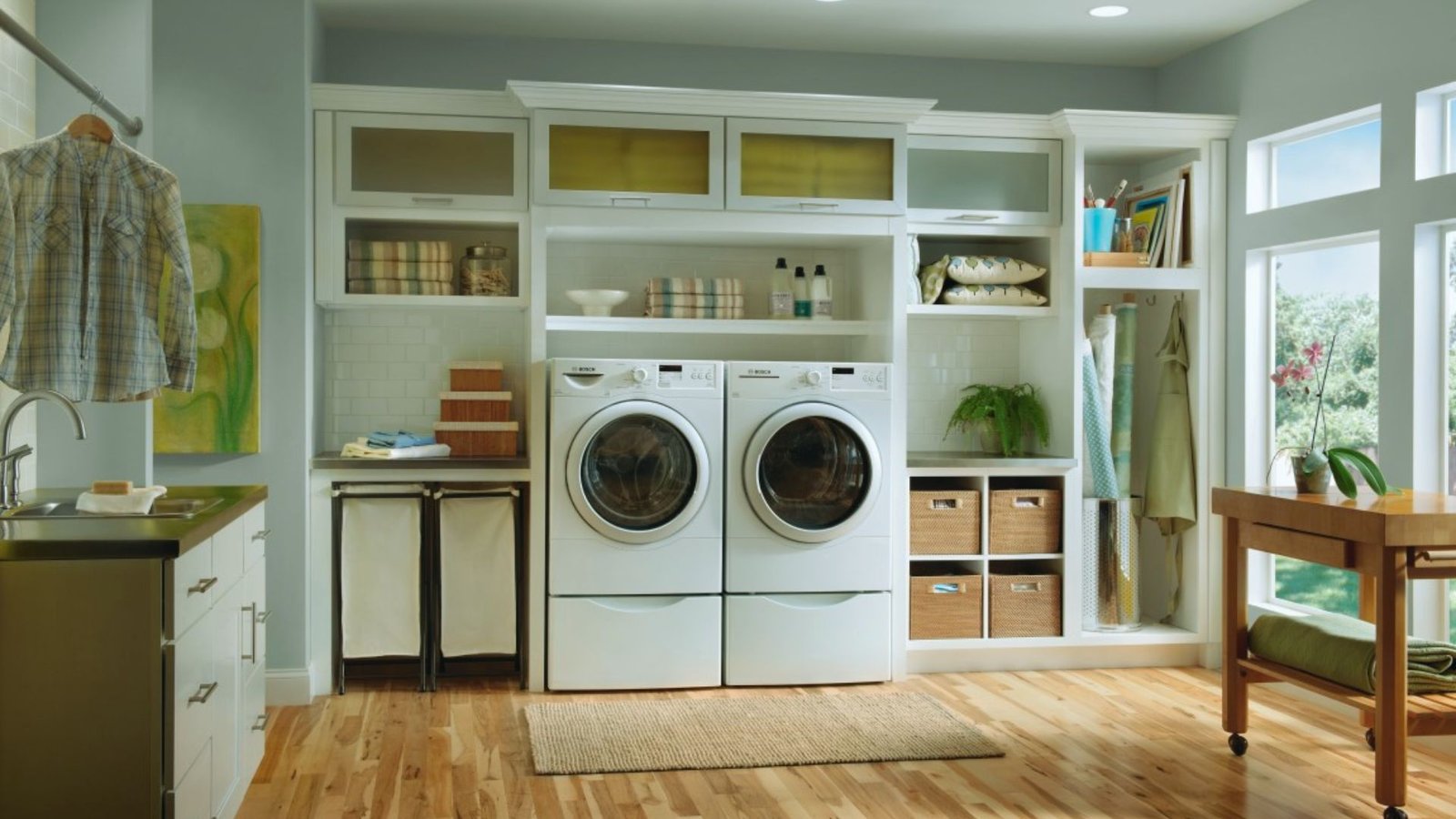 
2. Interior of a laundry room showcasing a washer and dryer, neatly arranged with laundry baskets and cleaning products.