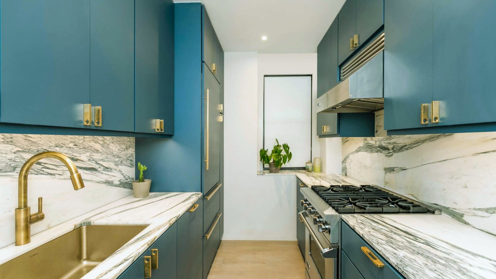  A modern kitchen featuring blue cabinets and elegant gold fixtures, creating a stylish and inviting atmosphere.