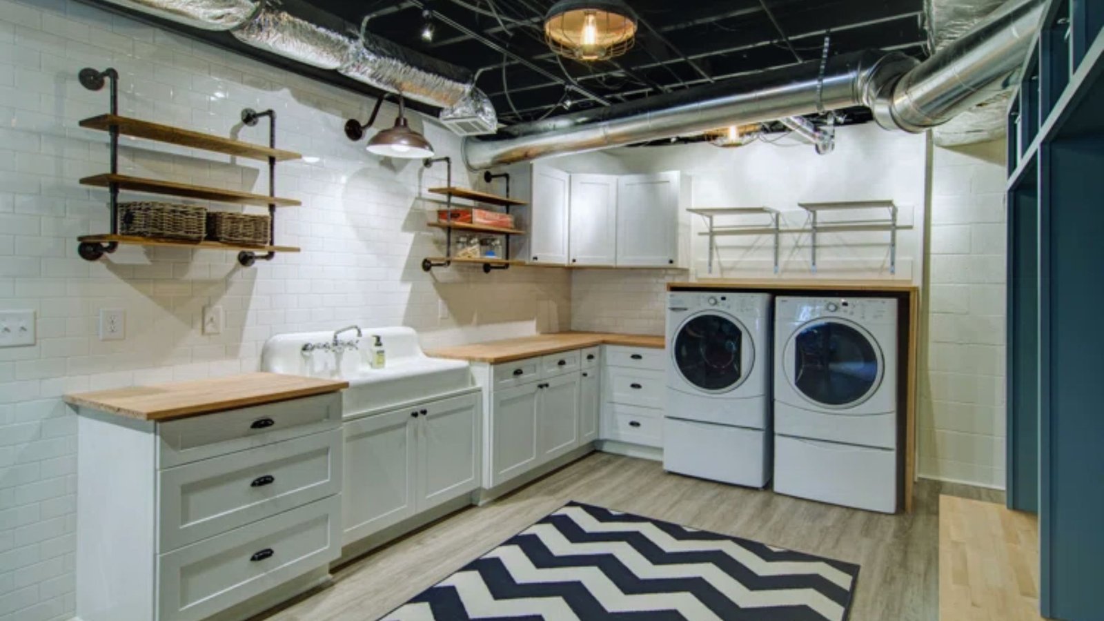 A functional laundry room equipped with a washer and dryer, surrounded by storage shelves and laundry essentials.