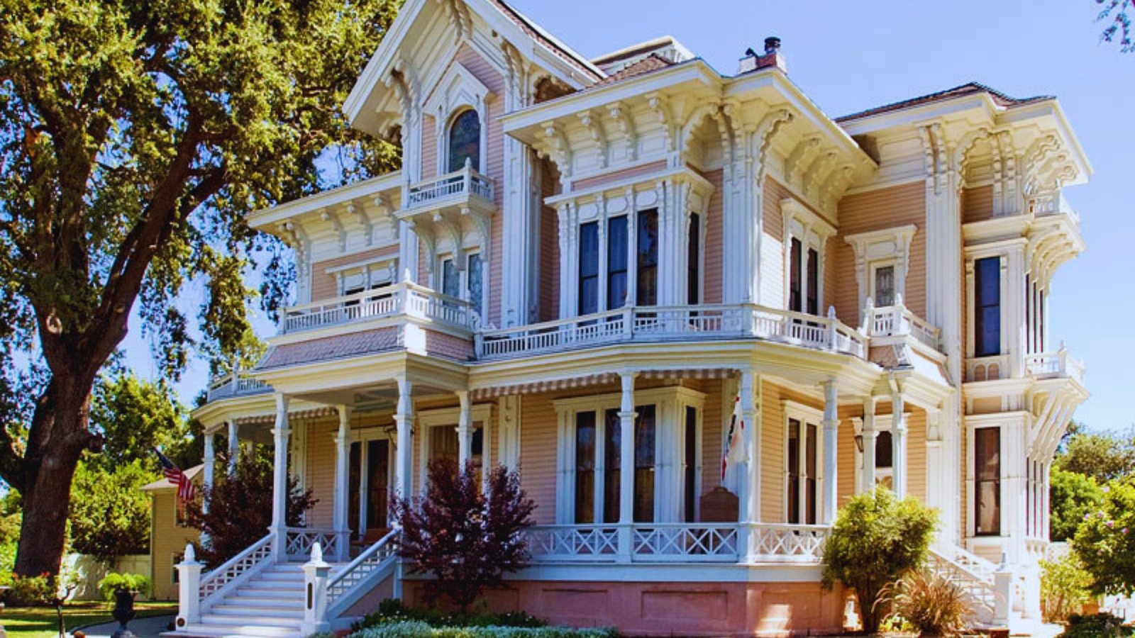 A large Victorian-style house featuring a welcoming porch and prominent steps leading to the entrance.