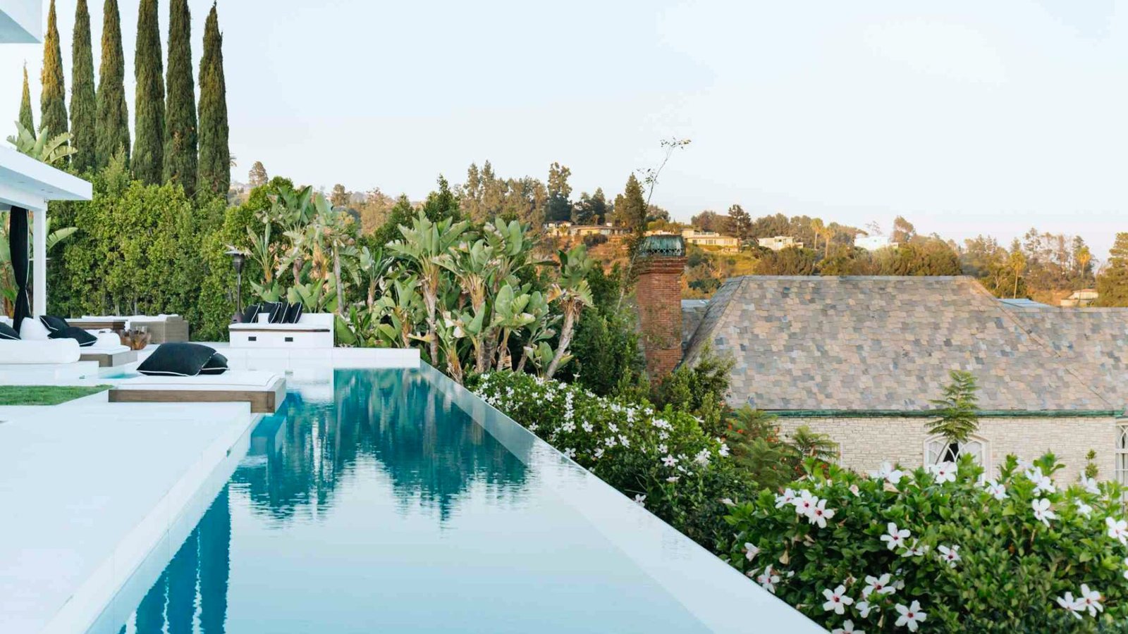 A serene pool nestled among lush greenery and trees, creating a tranquil outdoor oasis.