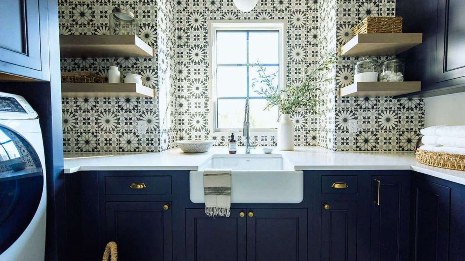 . A laundry room featuring blue cabinets, a washer, and a dryer, creating a functional and organized space.