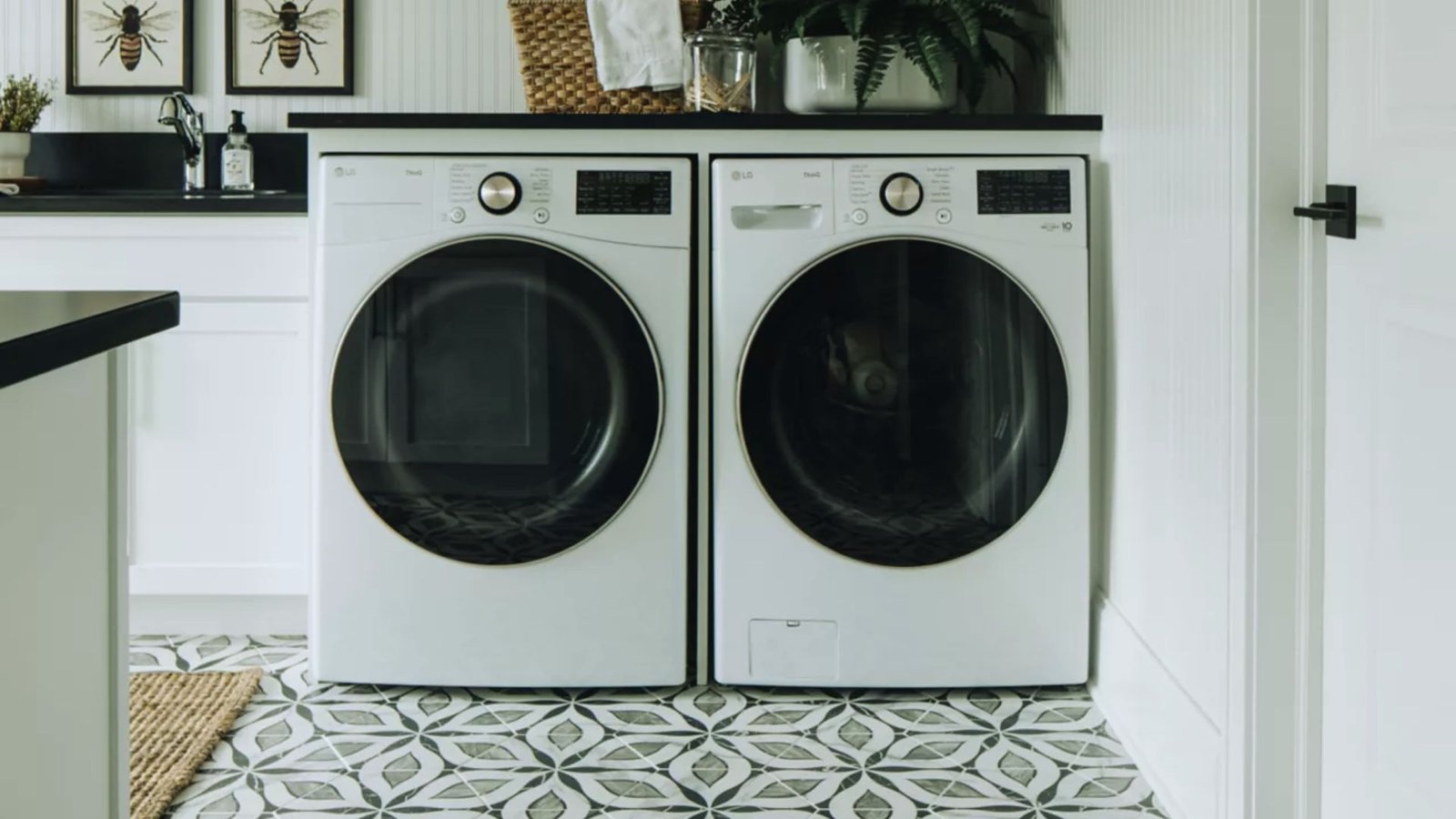 A laundry room featuring a washer and dryer, with shelves and cleaning supplies visible in the background.