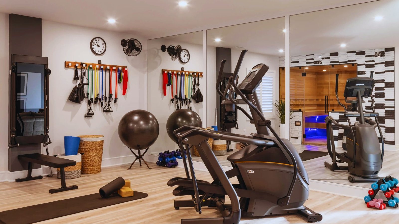 A home gym featuring various exercise equipment and large mirrors on the walls.