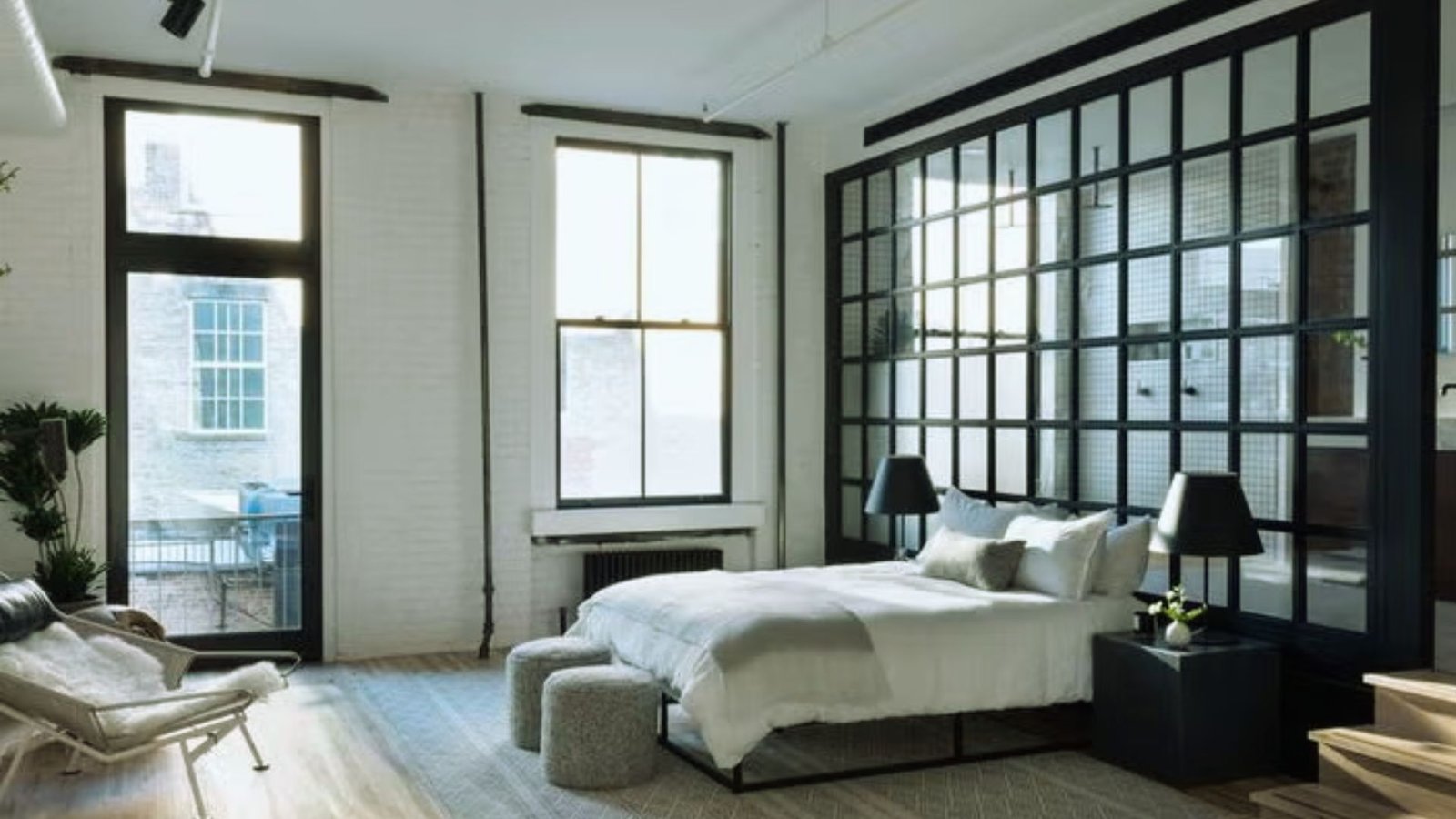 A cozy bedroom featuring a bed, a chair, and a window allowing natural light to enter the space.