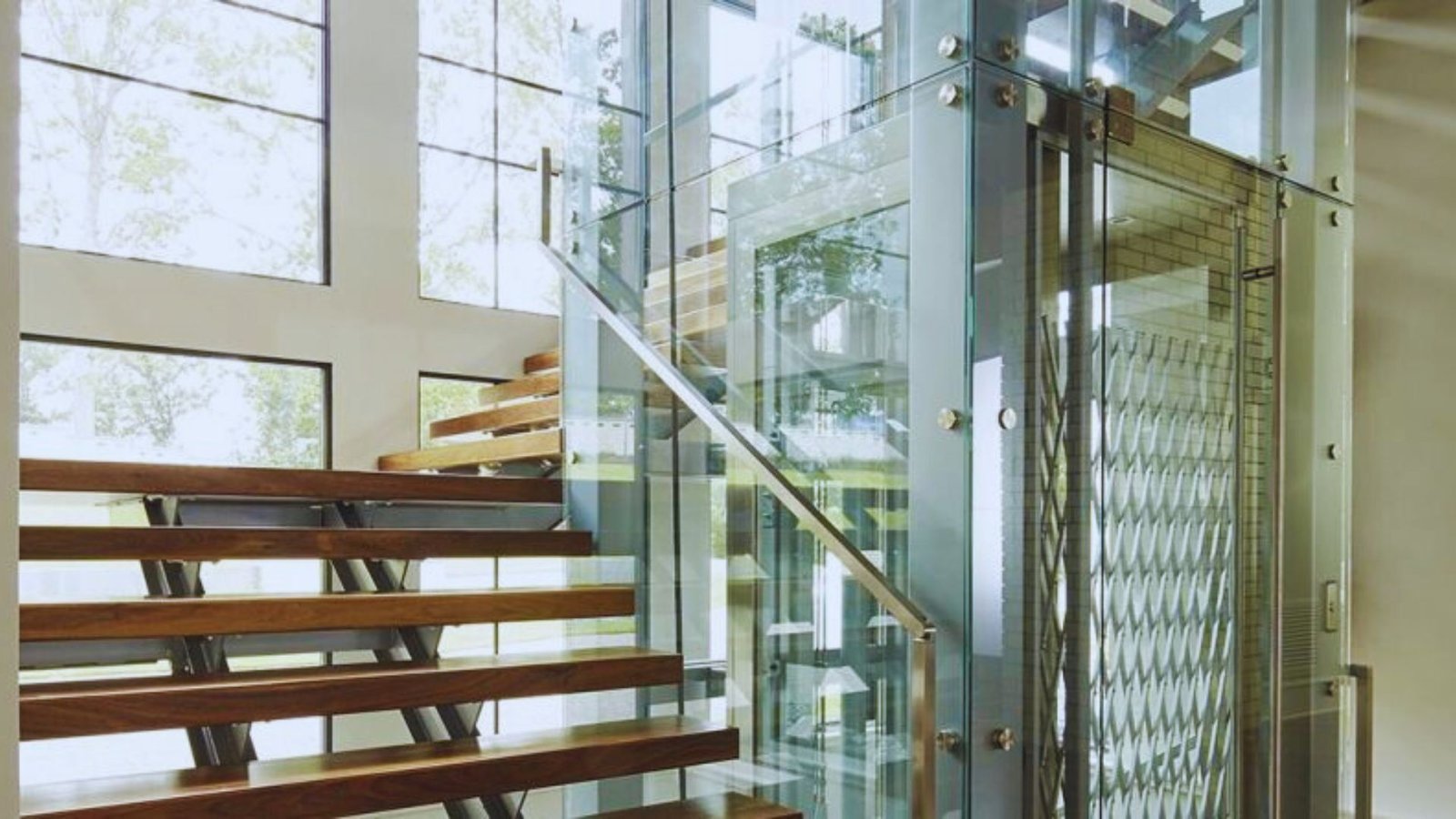 An elegant stairway with wooden treads and transparent glass railings, highlighting a sophisticated architectural style.